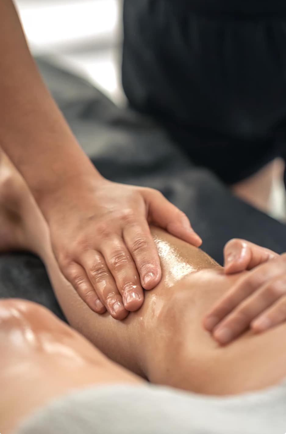 This is a picture close up of a leg
A person is massaging the leg with some oil